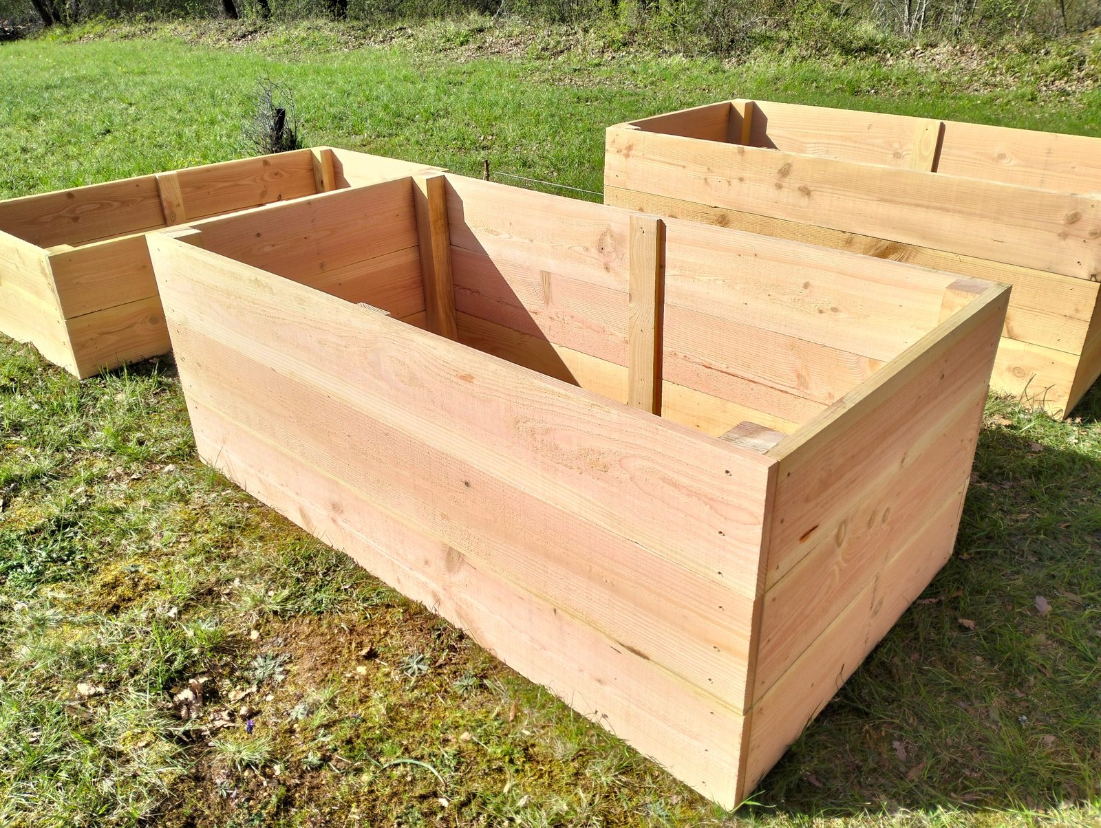 Fabrication artisanale de carrés potagers en bois dans un jardin en Dordogne